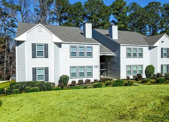 A large house with a grey roof and white walls.