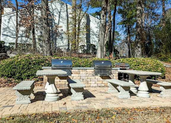 A set of four stone picnic tables are set in a brick circle.