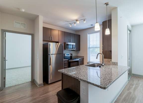 A kitchen with a granite countertop and stainless steel appliances.