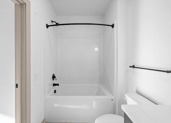 A white bathroom with a tub, toilet, and sink.