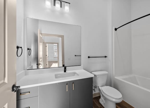 A white bathroom with a sink, toilet, and bathtub.