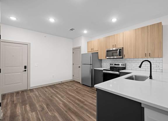 A kitchen with a white counter top and wooden cabinets.