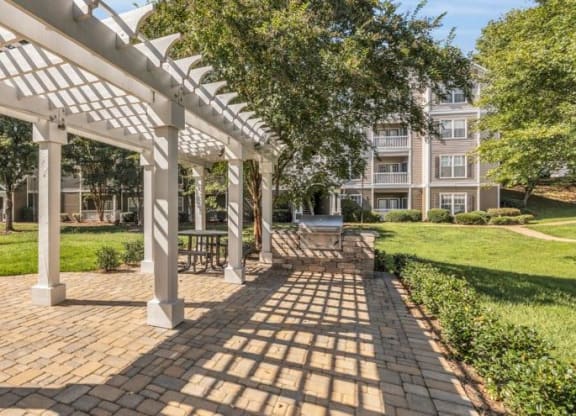 a pergola on a brick sidewalk in front of an apartment building at Marina Point, Chattanooga, TN