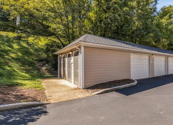 a white and tan garage with a driveway and trees at Marina Point, Chattanooga