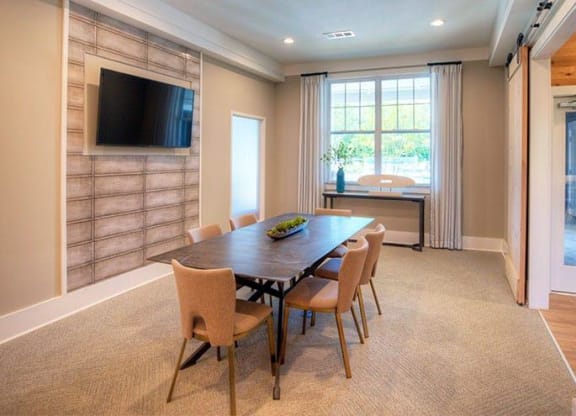 a dining room with a table and chairs and a television  at Lullwater at Big Ridge, Hixson, Tennessee