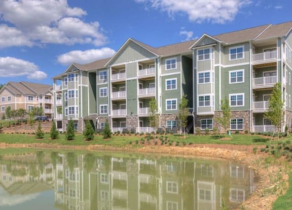 an apartment building with a pond in front of it  at Lullwater at Big Ridge, Hixson
