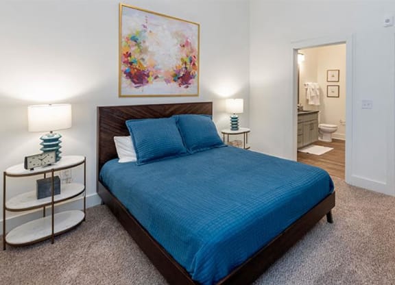 a bedroom with a bed and a door to a bathroom at Livingston Flats Apartments, Chesterfield, VA, 23832