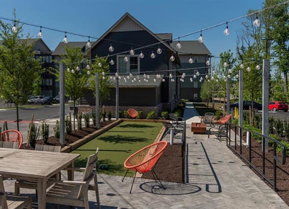 a patio with tables and chairs in front of a building at  Livingston Flats Apartments, Virginia