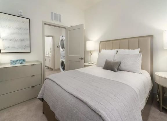 a bedroom with a bed and a washer and dryer at Artistry at Winterfield Apartments, Midlothian, VA, 23112