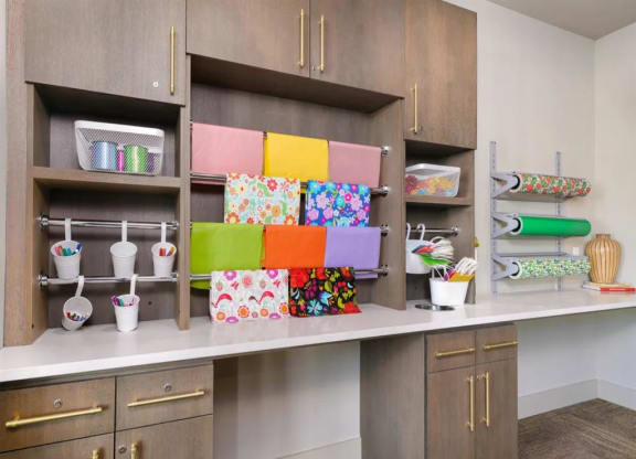 a craft room with wood cabinets and colorful boxes on the shelves at Artistry at Winterfield Apartments, Midlothian, Virginia