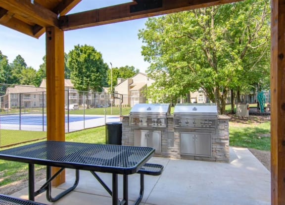 a patio with two grills and a table at Hunters Chase Apartments, Midlothian