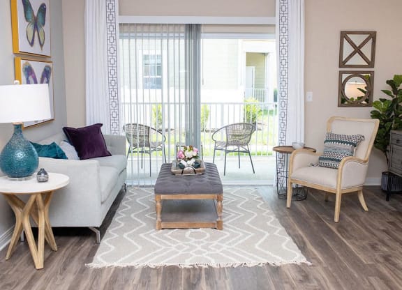 a living room filled with furniture and a large window  at Sapphire at Centerpointe, Midlothian, VA