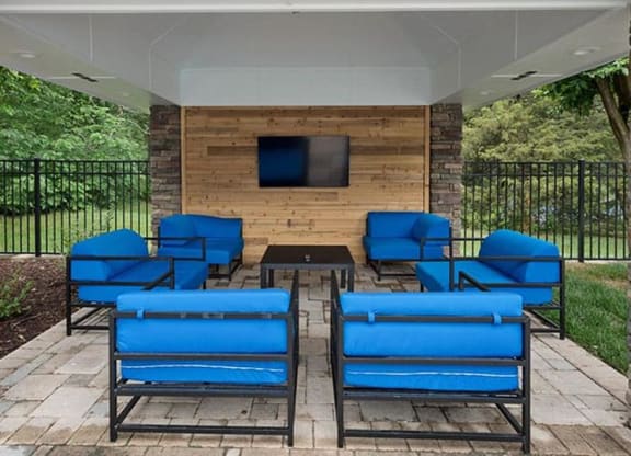 a patio with blue chairs and a table at Trails at Short Pump Apartments, Virginia