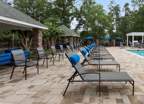 a pool with lounge chairs and umbrellas at Trails at Short Pump Apartments, Richmond, VA
