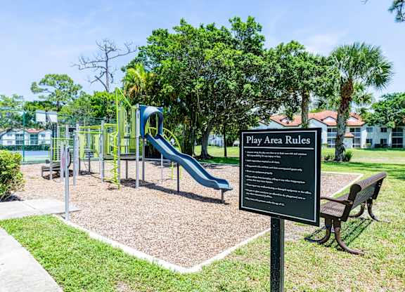 A playground with a sign that reads "Play Area Rules".