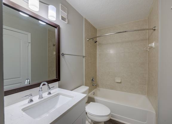 A white toilet sits next to a white sink in a bathroom.
