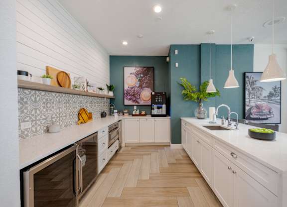 A modern kitchen with wooden floors and white cabinets.