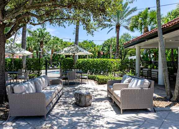 A patio with couches and trees.