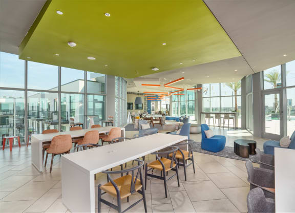 a lounge area with tables and chairs and large windows at Vista Brooklynn Apartments, Jacksonville, FL, 32202