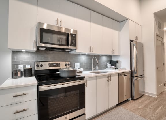 a kitchen with stainless steel appliances and white cabinets at Vista Brooklynn Apartments, Jacksonville, FL, 32202