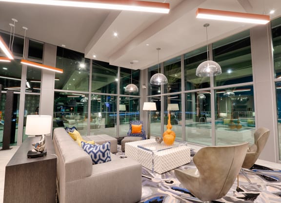 a living room with couches and chairs and large glass windows at Vista Brooklynn Apartments, Jacksonville, 32202