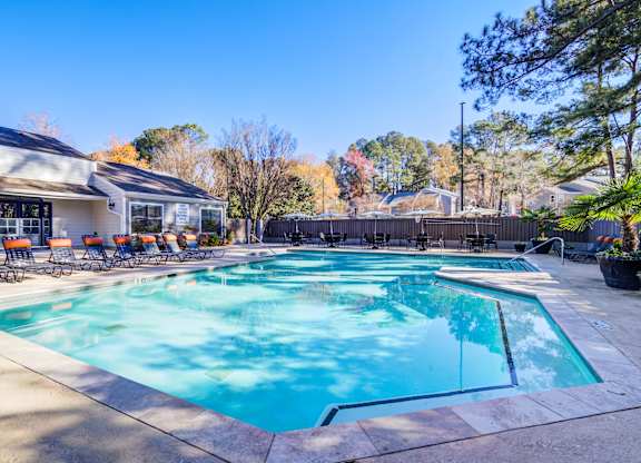 A large swimming pool with a slide and sun loungers.