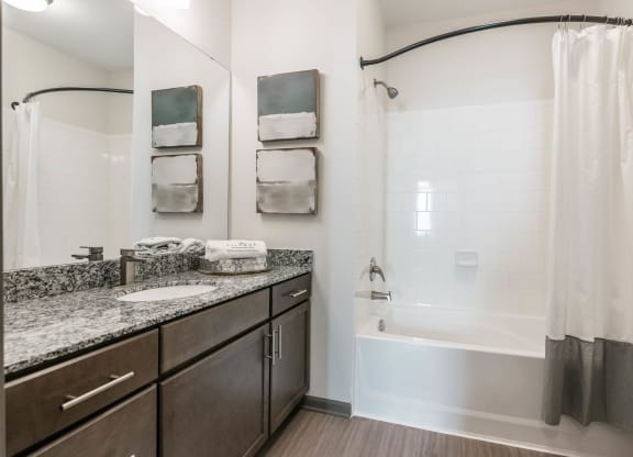 a bathroom with a tub and a sink and a mirror at Village at Westland Cove Apartments, Tennessee, 37922