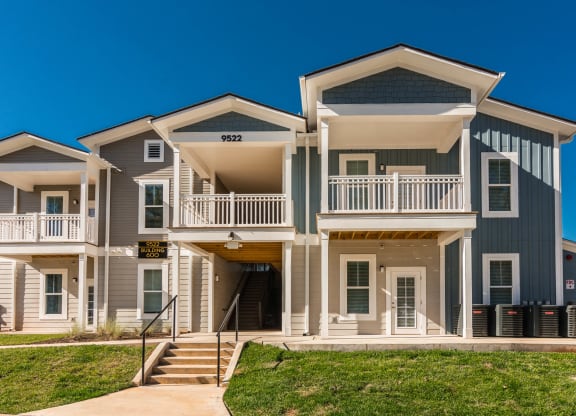 an apartment building with stairs and a sidewalk in front of it at Village at Westland Cove Apartments, Knoxville, TN