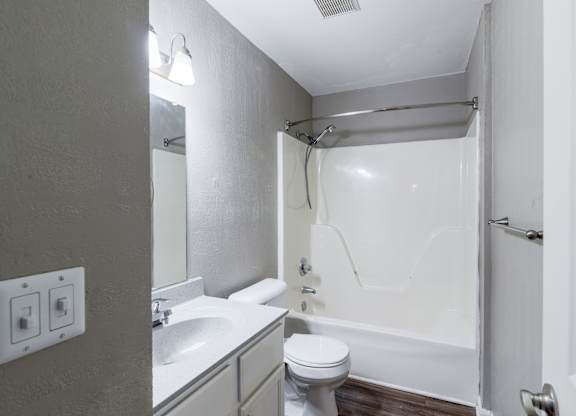 A white bathroom with a toilet, sink, and bathtub.