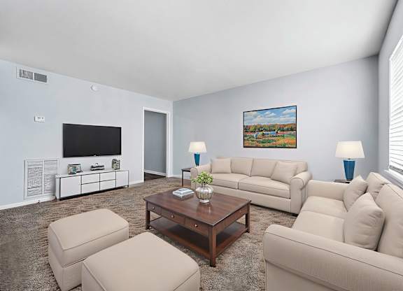 A living room with a large couch, a coffee table, and a painting on the wall.