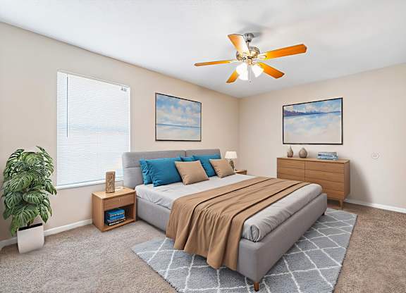 A bedroom with a bed, nightstand, and a ceiling fan.