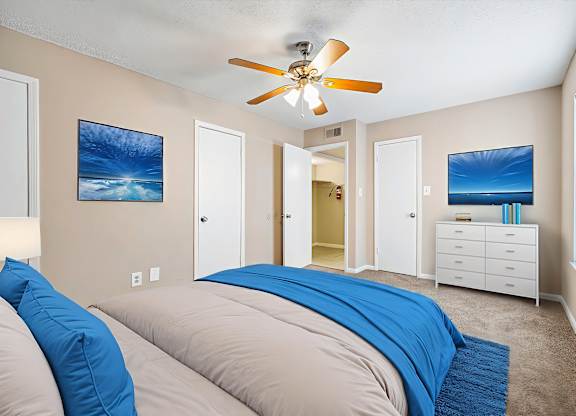 A bedroom with two beds and a ceiling fan.