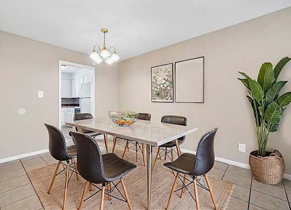 A dining room with a table and chairs.