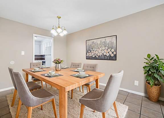A dining room with a wooden table and chairs.