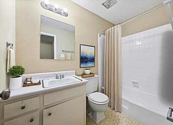 A bathroom with a toilet, sink, and shower.