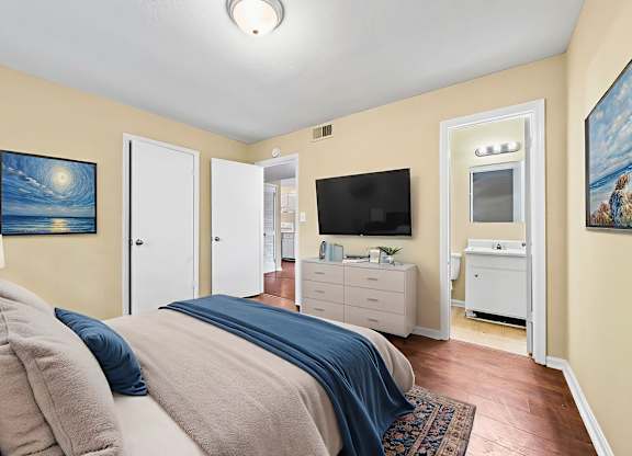 A bedroom with a bed, dresser, and television.