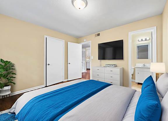 A bedroom with a bed, dresser, and mirror.