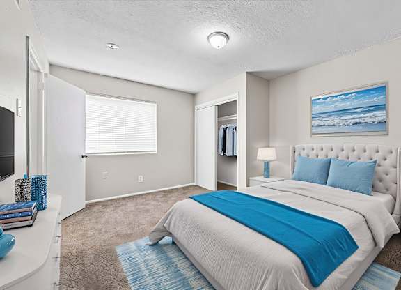 A bedroom with a large bed and a painting of the beach on the wall.