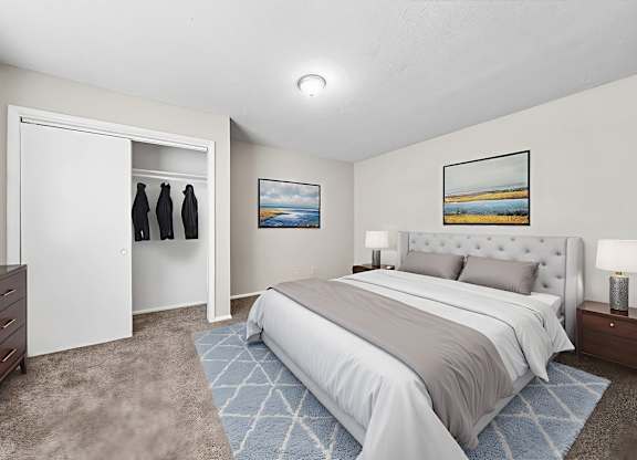 A bedroom with a large bed and a painting on the wall.