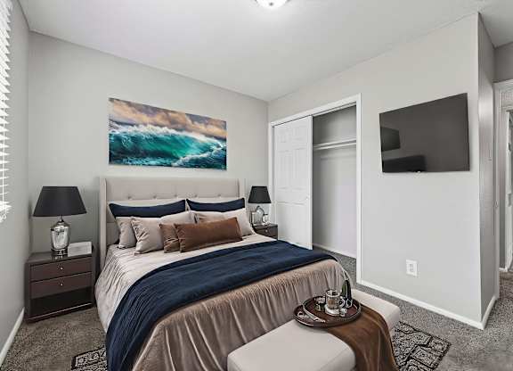 A bedroom with a large bed and a painting of a wave on the wall.