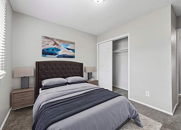 A bedroom with a large bed and a painting on the wall.