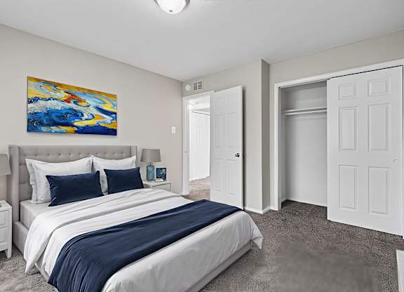 A bedroom with a large bed and a painting on the wall.