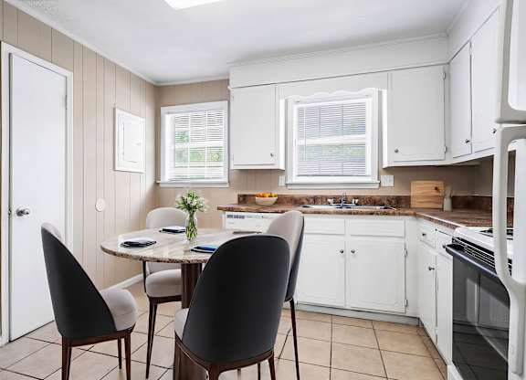 A kitchen with a table and chairs.