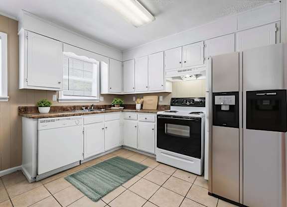A kitchen with white cabinets and appliances.