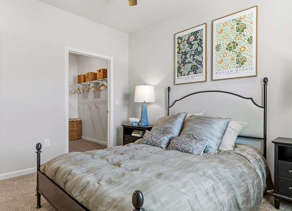 A bedroom with a bed, nightstand, and lamp.