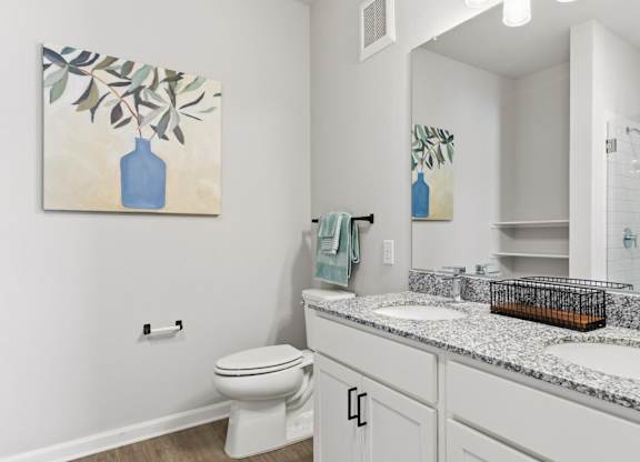 A bathroom with a toilet, sink, and mirror.