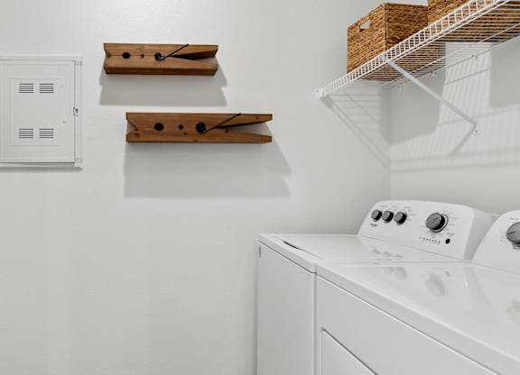 A white dryer is sitting in a laundry room.