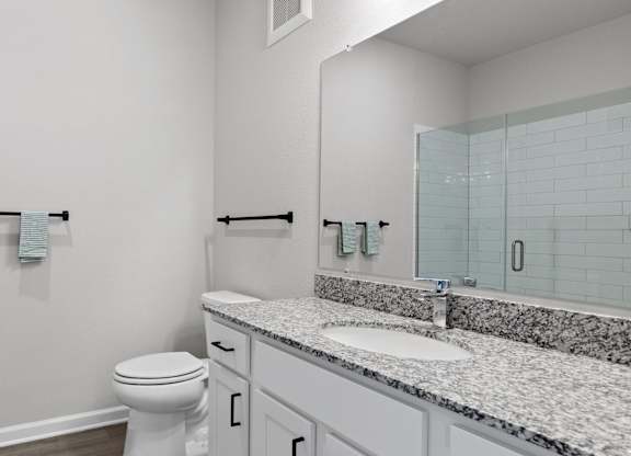 A white toilet sits next to a sink in a bathroom.