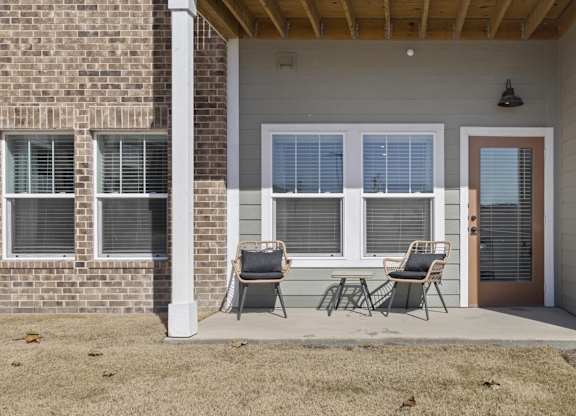 A house with a brown brick wall and a white door.
