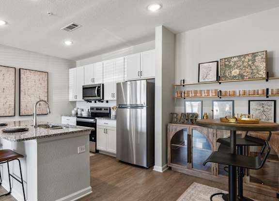 A kitchen with a white countertop and a stainless steel refrigerator.